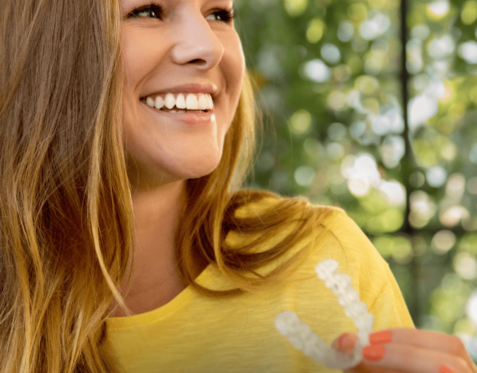 Invisalign aparatić za zube kraj mlade djevojke u žutoj majici.